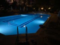 Pool lighting in backyard at night for family lifestyle and living area. Luxury design with good light and clean landscaping Royalty Free Stock Photo