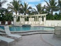 Beautiful pool area with palm trees and lounge chairs.