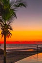 Fiery sunset over the Pacific Ocean, seen from a relaxing pool. Royalty Free Stock Photo