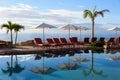 Pool reflection of palm trees and beach chairs at vacation resort. Royalty Free Stock Photo