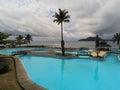 A pool at a resort with a palmtree on center and the ocean as background,Ilheu das Rolas,Sao Tome