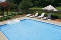 Pool Side with Lounge Chairs and Umbrella Royalty Free Stock Photo