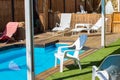 Pool side villa back yard space with white deck chair in summer sunny day time vacation season Royalty Free Stock Photo