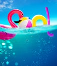 Pool text made of inflatable water toys underwater split photo Royalty Free Stock Photo