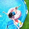 Pool time. Girl has fun in a summer metal frame pool. Royalty Free Stock Photo