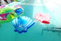 Colorful pool toys floating on the aqua colored water if a Mexico pool.