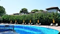 Pool with umbrellas, lounge chairs and red roof villas Royalty Free Stock Photo