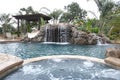 A pool with a waterfall in a luxury backyard