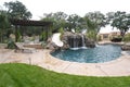 A pool with a waterfall in a luxury backyard Royalty Free Stock Photo