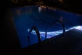 Pool and waterfall at night - vacation background. Colorful light decoration. Freezelight Royalty Free Stock Photo