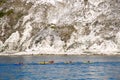 Canoeists rowing next to Jurassic coast chalk cliffs Royalty Free Stock Photo