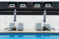 Poolside beach bed with umbrella and white wall Royalty Free Stock Photo