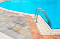 Poolside with blue clear water and ladder, detail