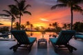 poolside lounge chairs with sea and sunset backdrop Royalty Free Stock Photo