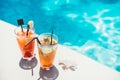 Poolside symmetric cocktails served cold at pool bar with mojito and gin and tonic lemonade