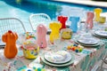 poolside table with inflatable pool toy decorations, swimsuitpatterned china, and mini beach balls Royalty Free Stock Photo