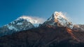 Poonhill view of Annapurnas. Warm pink and orange sunrise light over Annapurna mountain range with blue sky and beautiful clouds. Royalty Free Stock Photo