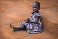 A poor African girl begs for alms in the capital Kampala