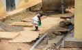 Poor African girl playing in front of her house