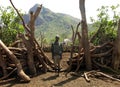 Poor African villager front livestock corral made cut tree branches