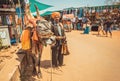 Poor asian musician with flute playing songs for money and cow food on traditional market street