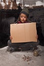 Poor beggar boy on the street with a cardboard sign Royalty Free Stock Photo