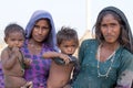 Poor beggar women and children begs for money from a passerby in Pushkar. India