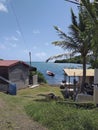 Poor Caribbean fishermen`s huts and motorboat in Caribbean sea waters with tropical blue sky. Construction and Architecture of th