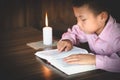 Poor children read books using candles for lighting., Disadvantaged Children doing homework, Education Concept