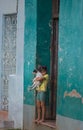 Poor Cuban girl capture portrait in traditional colorful colonial alley with old life style, in old city, Cuba, America.
