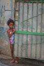 Poor Cuban girl capture portrait in traditional colorful colonial alley with old life style, in old Havana, Cuba, America.