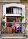 Poor Cuban mother and child capture portrait in traditional colorful alley with old colonial house, in old Havana, Cuba, America.