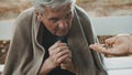 Poor elder homeless man receiving coins from woman Royalty Free Stock Photo