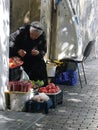 Poor, elderly woman selling fruit on street, Tbilisi old town, Georgia