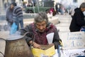 Poor elderly woman sells chestnuts