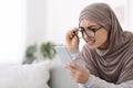 Poor Eyesight. Muslim Woman In Glasses Holding Smartphone, Having Vision Problem