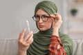 Senior Middle-Eastern Woman In Eyeglasses Squinting Eyes Reading Message Indoor Royalty Free Stock Photo