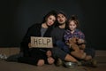 Poor family with HELP sign on floor