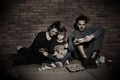 Poor family sitting on floor near wall Royalty Free Stock Photo