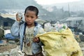 Poor Filipino boy gathering plastic on landfill
