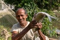 A poor fisherman showing a big Catla fish Labeo catla with a proud smile on his face