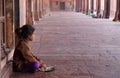 A poor girl eating in Fatehpur Sikri complex, India