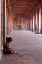 A poor girl eating in Fatehpur Sikri complex