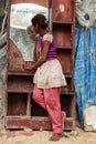 A poor girl looking in a mirror from a urban slum in new delhi