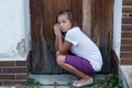 Poor girl sad in front of door Royalty Free Stock Photo