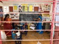 Poor government preschool teacher and her group of kids raising their hands and having some fun at school