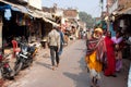 Poor hindu people walking on the Indian street at the beautiful sunny day, India.