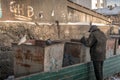 The poor homeless man searching for food in a dirty trash container in Ulan-Ude.