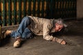 Poor homeless old man`s sitting on the floor feel sad stress no money sitting on sidewalk street, unemployed miserable street old Royalty Free Stock Photo