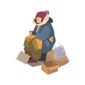 Poor homeless woman dressed in ragged outerwear sitting on street beside pile of garbage, holding paper cup and begging